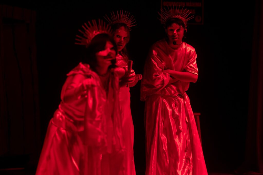 El diseño de iluminación y la presencia de las musas crearon un ambiente infernal y satírico para enmarcar la historia.